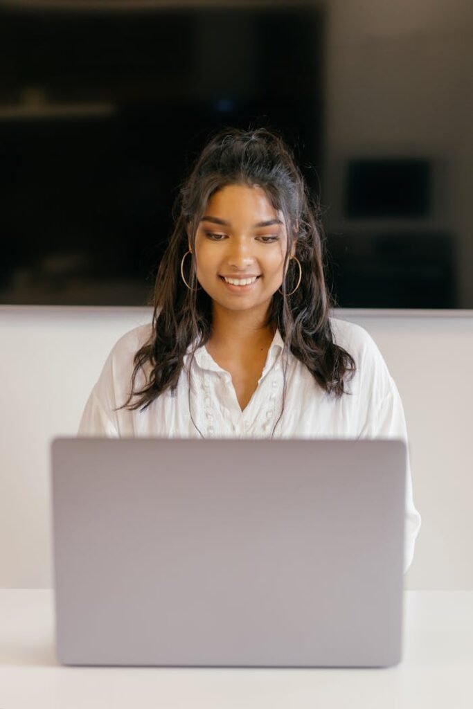 pexels-photo-9159640 Female Student Smiling while Using a Laptop
